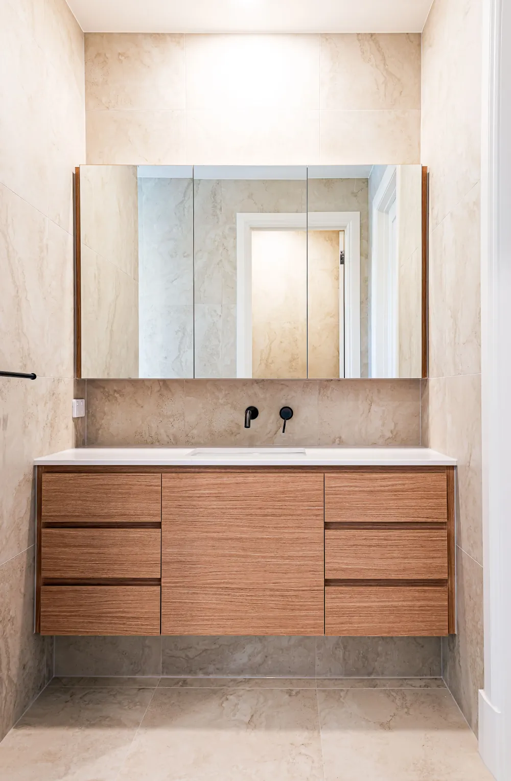 Shower with brass fixtures and stone tiling